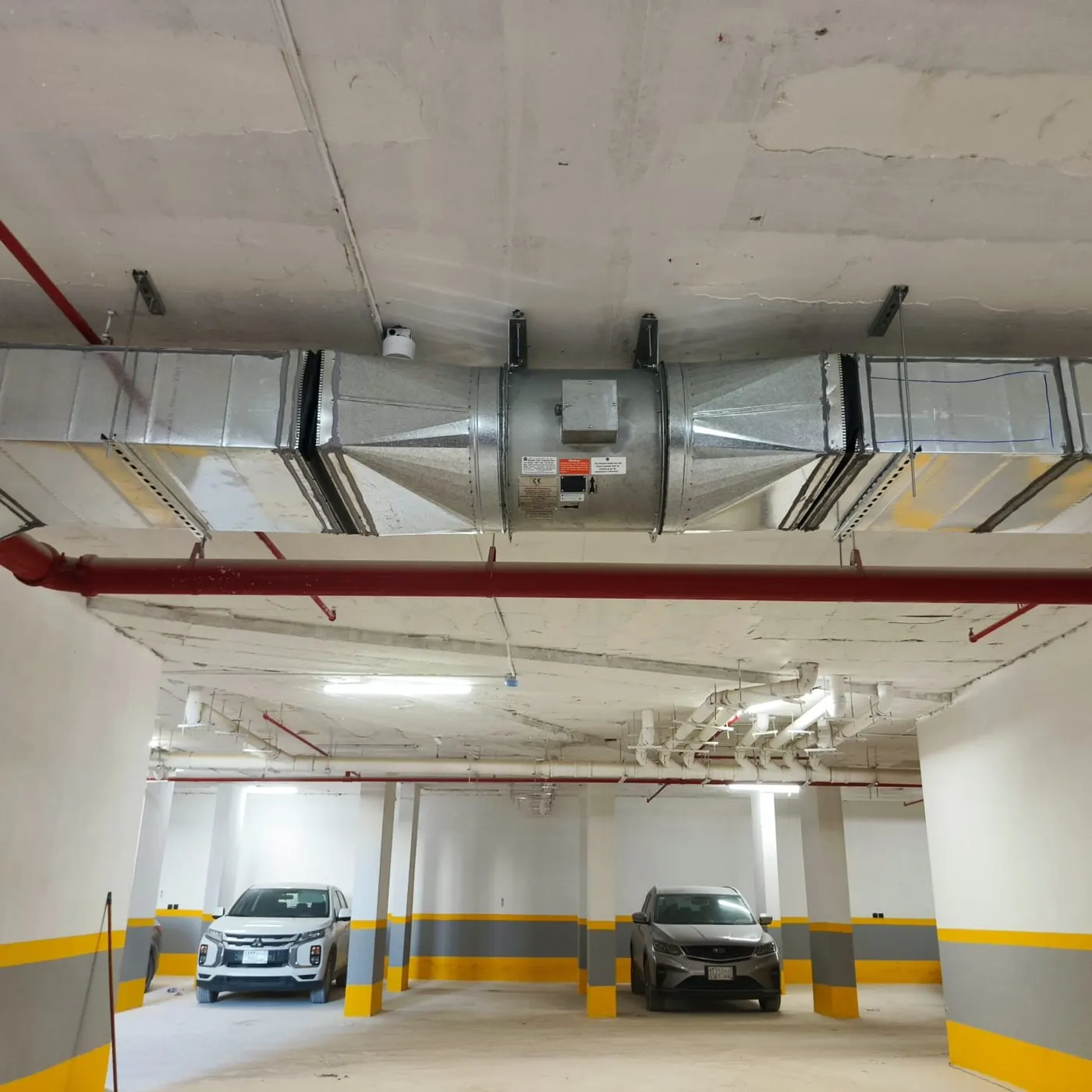 Large ventilation duct and fan section above a car park